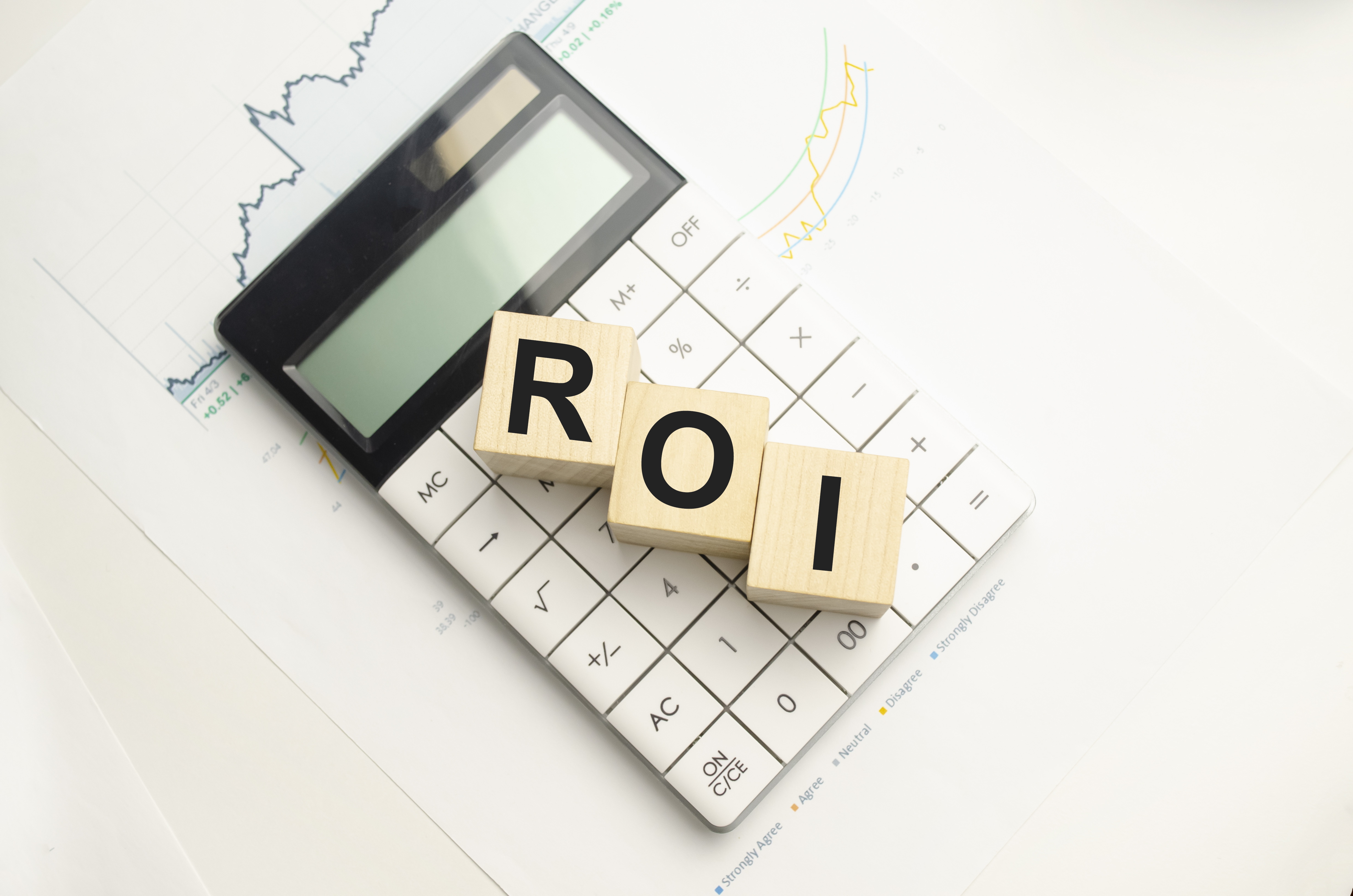 roi-return-investment-written-wooden-cubes-calculator-pen-light-background-investment-concept-high-quality-photo