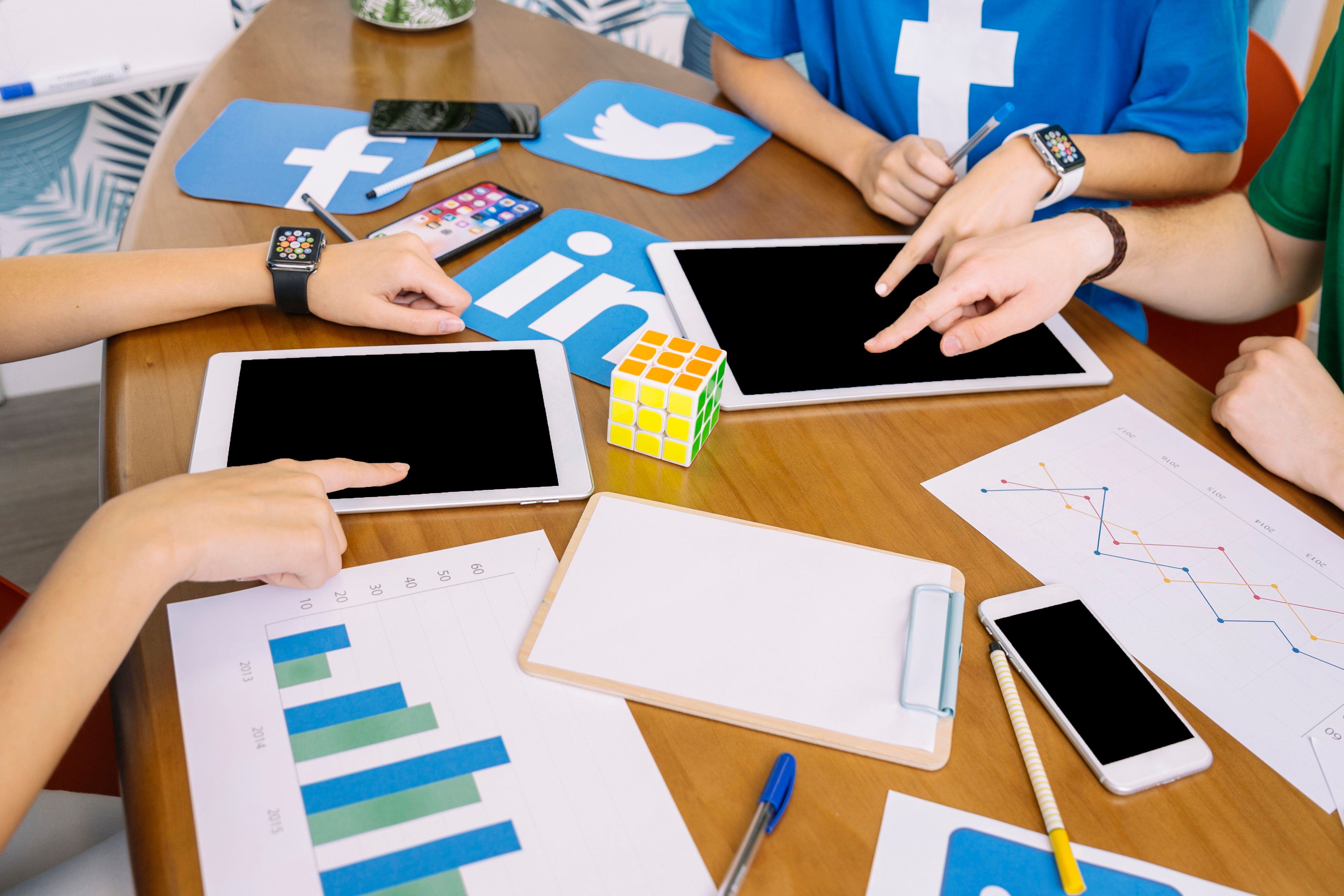 social-media-team-using-digital-tablet-with-social-media-icons-desk